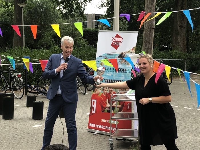 Wethouder Hans Buijtelaar overhandigt de stimuleringsprijs uit aan Deborah Drenth van basisschool De Windroos