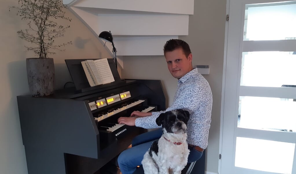 Hein van de Veen speelt thuis op zijn Johannes-orgel, samen met de hond Woezel.