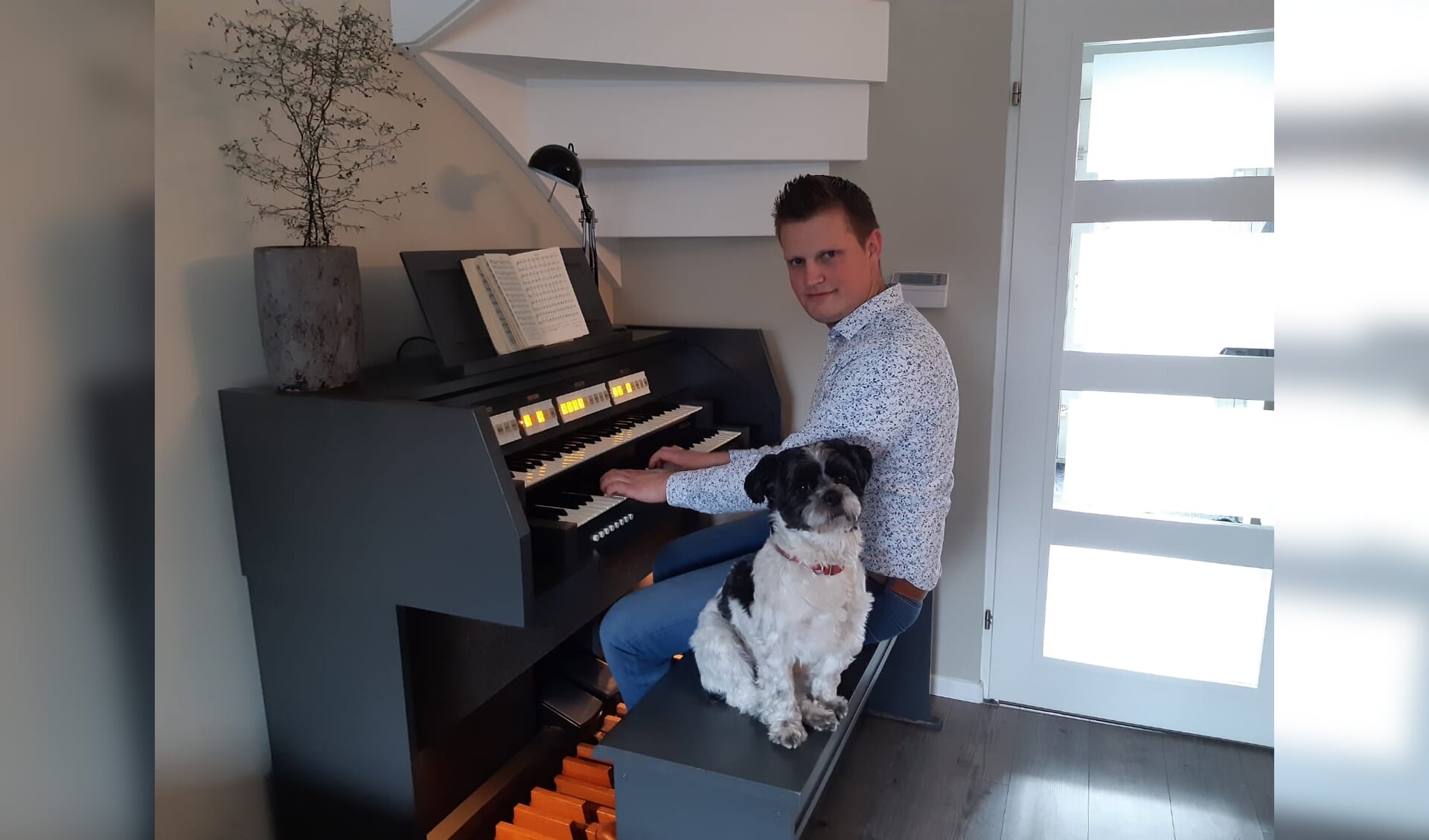 Hein van de Veen speelt thuis op zijn Johannes-orgel, samen met de hond Woezel.