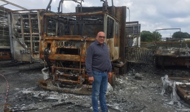 Gertjan Tomassen voor de verbrande vrachtwagens, een dag voor ze werden opgeruimd. 