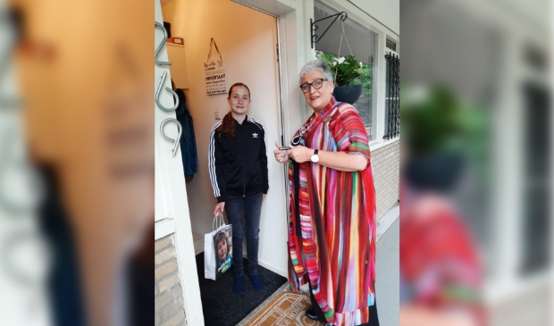 Jonge mantelzorger Anouk krijgt een tasje aangeboden door Corry, medewerkster van Mantelzorg & Meer.