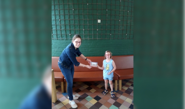 Educatiemedewerker Serah Hoeks overhandigt de prijs aan Cela Groenenberg (5) uit Gorinchem.