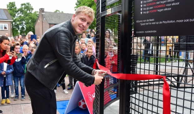 <p>Donny van de Beek schenkt op deze archieffoto zijn oude basisschool in Nijkerkerveen een pannaveld, in juni vorig jaar.</p>