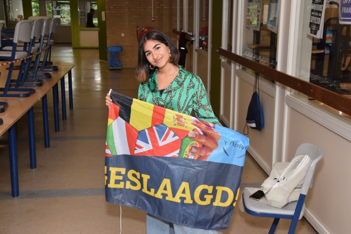 Een trotse leerling met haar welverdiende vlag.