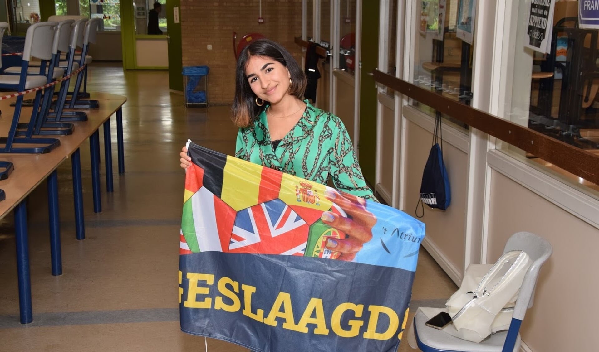 Een trotse leerling met haar welverdiende vlag.