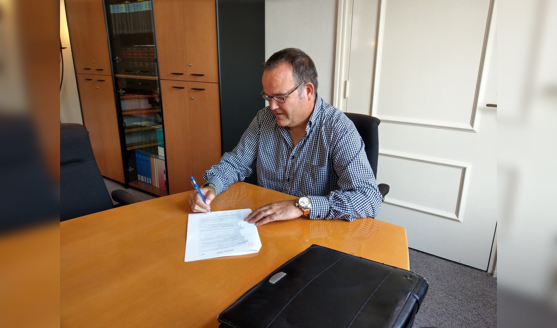 Voorzitter Robert Tiesing zet zijn handtekening onder de oprichtingsacte van de Stichting Kinderboerderij Scherpenzeel.