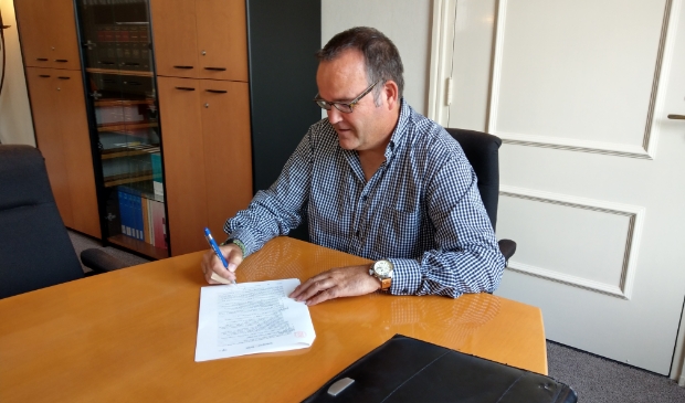 Voorzitter Robert Tiesing zet zijn handtekening onder de oprichtingsacte van de Stichting Kinderboerderij Scherpenzeel.