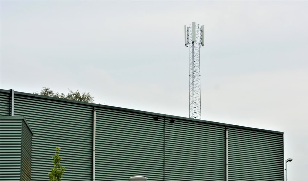 De nieuwe zendmast steekt ver boven sporthal Oosterbos uit