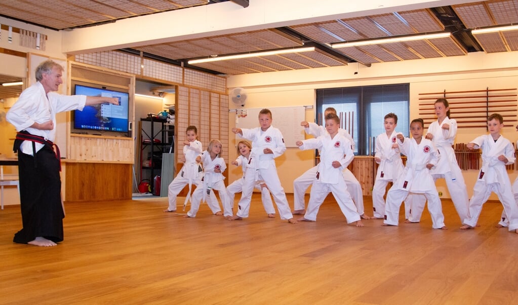 Karateles voor kinderen in Scherpenzeel. Links Hans Cleton.