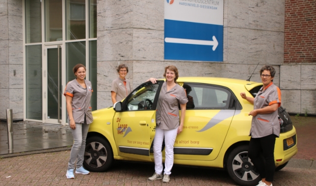 Het wijkteam voor de entree naar het souterrain van het Gezondheidscentrum, waar het nieuwe wijkkantoor is gehuisvest.