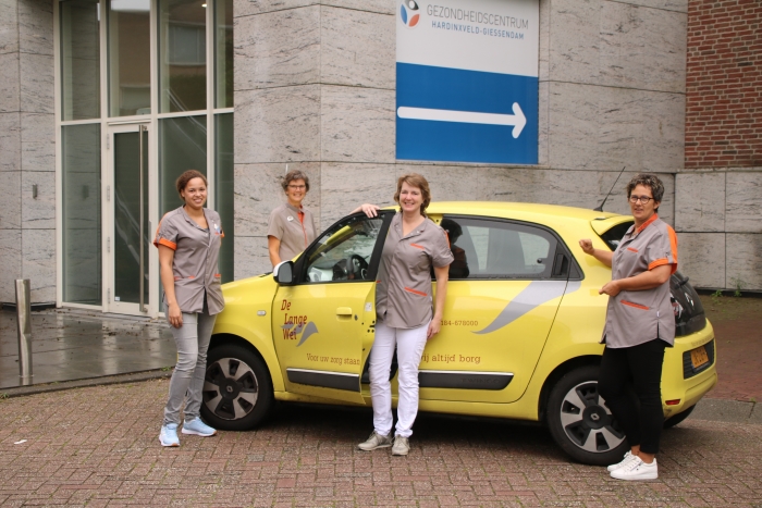 Het wijkteam voor de entree naar het souterrain van het Gezondheidscentrum, waar het nieuwe wijkkantoor is gehuisvest.