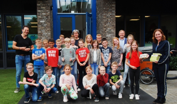 Naast wethouder Marieke Teunissen de jarige Fleur die als eerste de wijkgame ontving en de leerlingen van groep 6 van De Borgwal.
