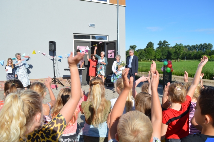 Juf Nelleke en haar man Mart Jan genieten zichtbaar van het uitzwaailied dat hen wordt toegezongen