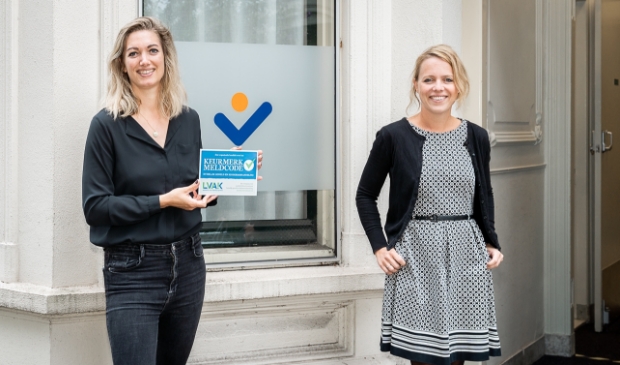Aandachtsfunctionaris Annelies Brasjen (links) en Joëlle van Kommer bij Stadsring51 met het Keurmerk ‘Meldcode huiselijk geweld’.