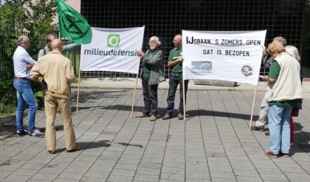 De actievoerders protesteren voor de deuren van de ijsbaan.