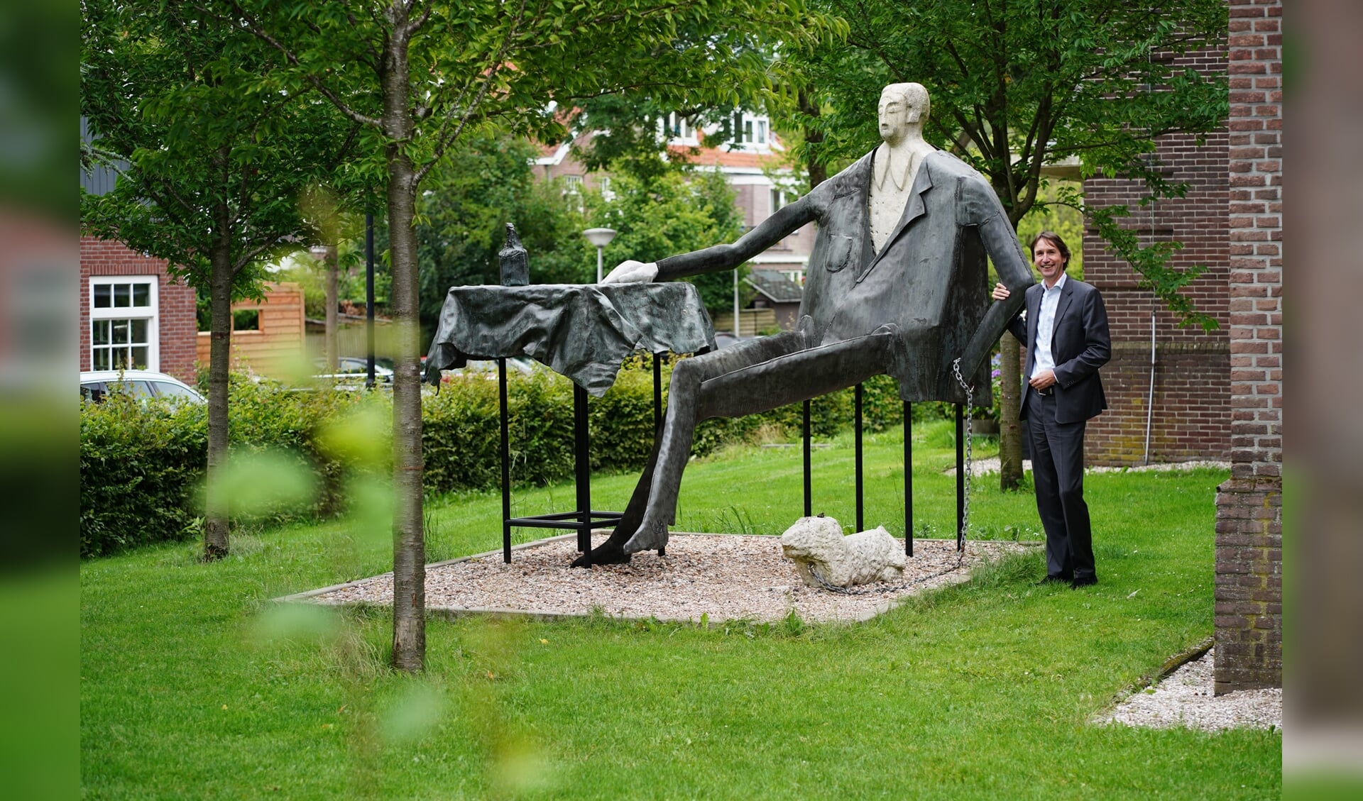 Wethouder Raat bij het beeld Dandy in het Oude Dorp.