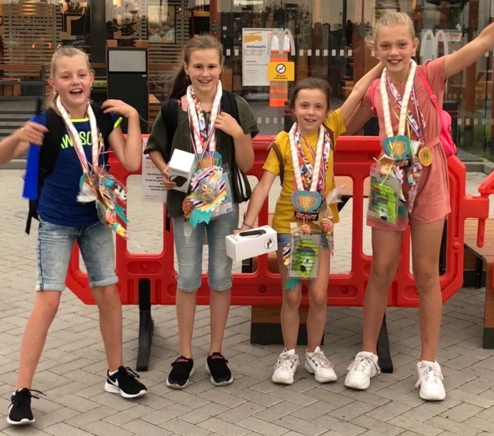 Tirsa, Sarah, Britt en Fenna staan trots op de foto met hun medailles.
