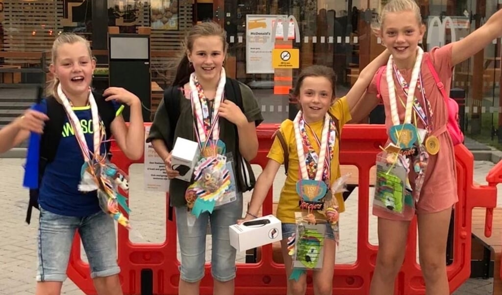 Tirsa, Sarah, Britt en Fenna staan trots op de foto met hun medailles.