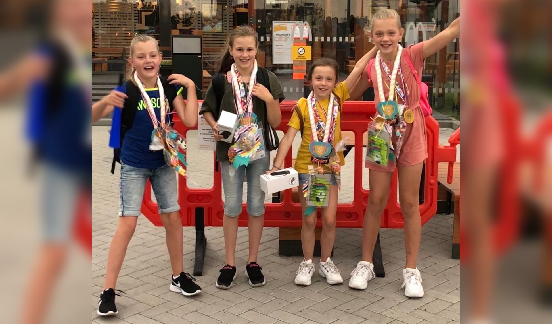 Tirsa, Sarah, Britt en Fenna staan trots op de foto met hun medailles.