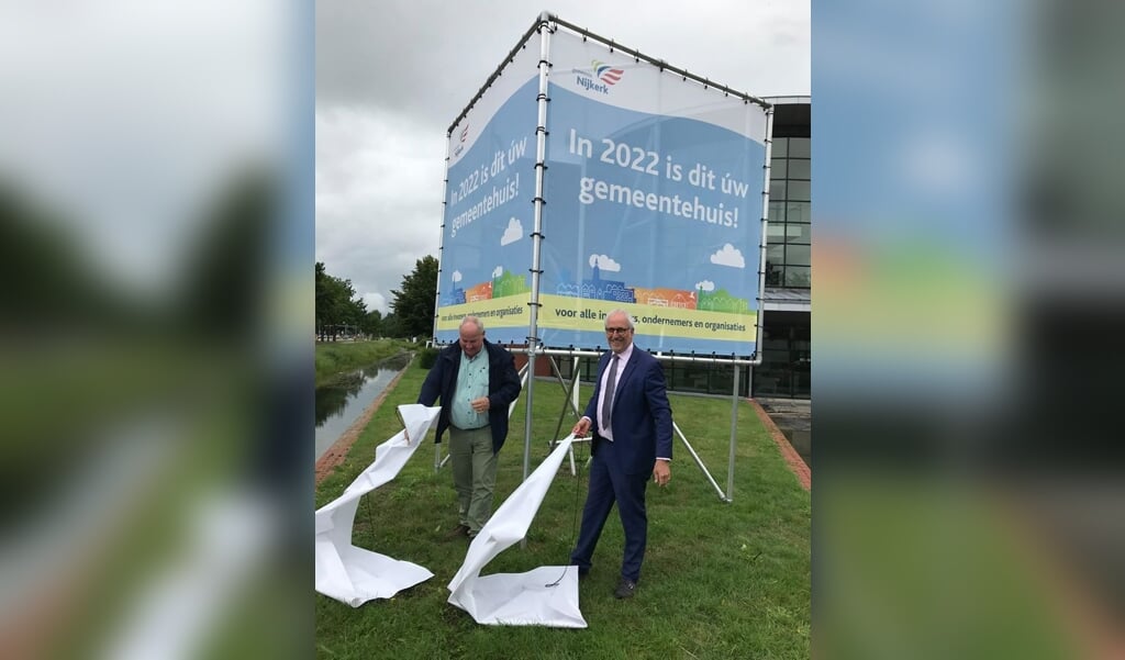 Burgemeester Renkema en Aart Klompenhouwer onthulden in juli samen het laatste stuk van de bouwdoeken voor het nieuwe Nijkerkse gemeentehuis. 