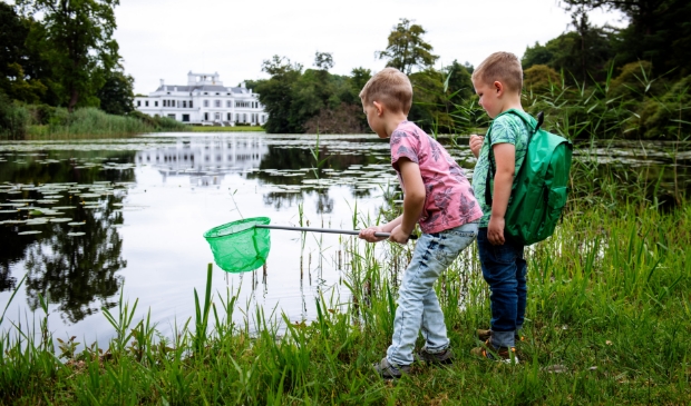 Kinderen mogen met een schepnet vissen in de paleisvijver.