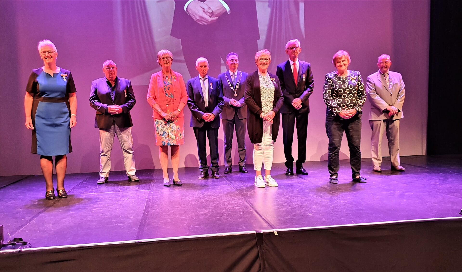Burgemeester Isabelle met de acht gedecoreerden in Theater aan de Slinger