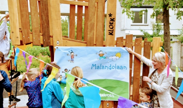 Wethouder Floor Gordon trekt met kinderen de openingsposter weg; het speelveld is officieel geopend.