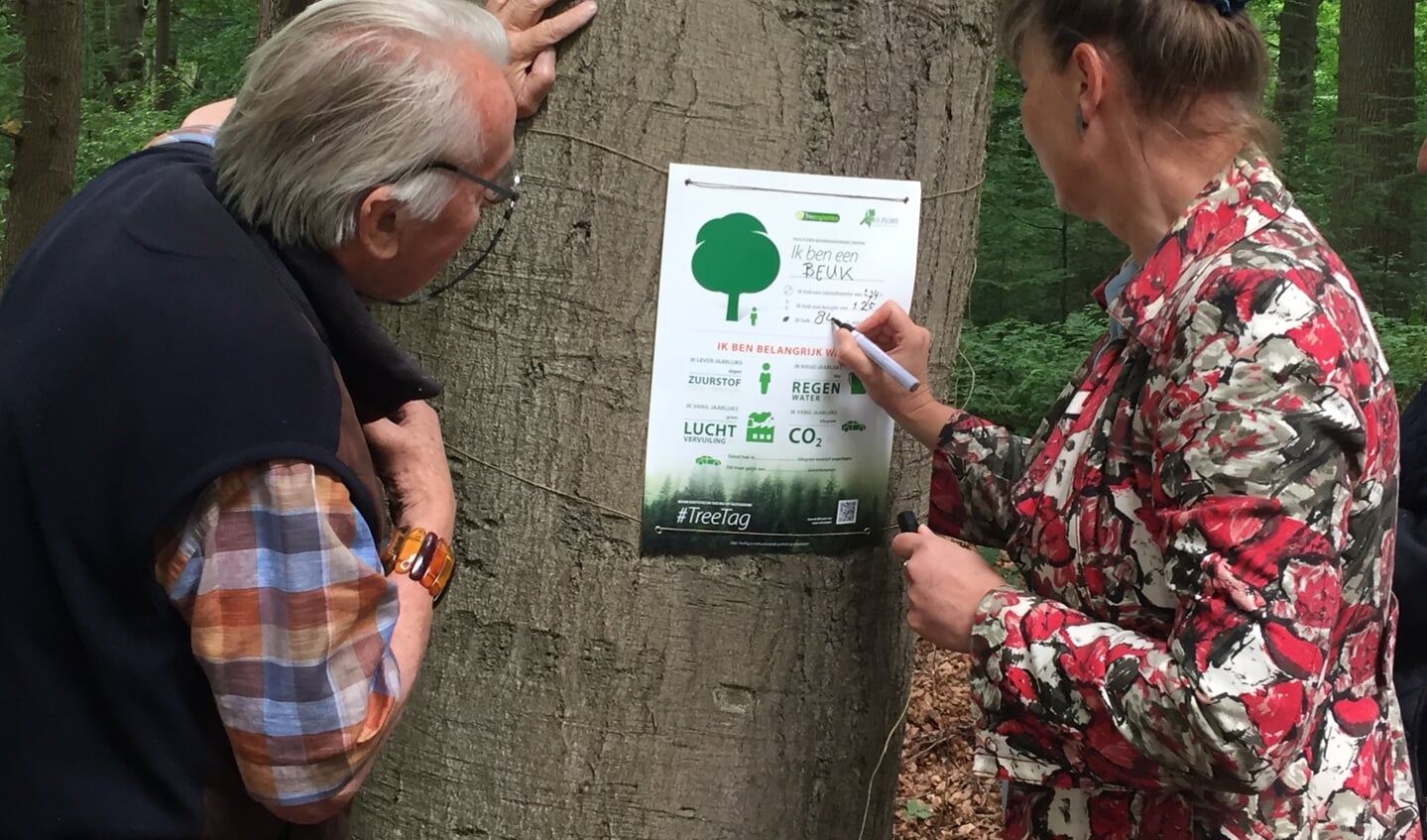 Onder toeziend oog van Jørn Copijn vult Urgenda-directeur Marjan Minnesma het boompassoort in van een van de 680 beuken aan de Broekhuizerlaan.
