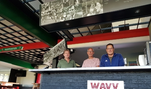 Geurt Hellegering, Ton Bongers en Fred Albers (vlnr) staan vol trots achter de volledig gerenoveerde bar, opgesierd met een fraaie fotocollage.