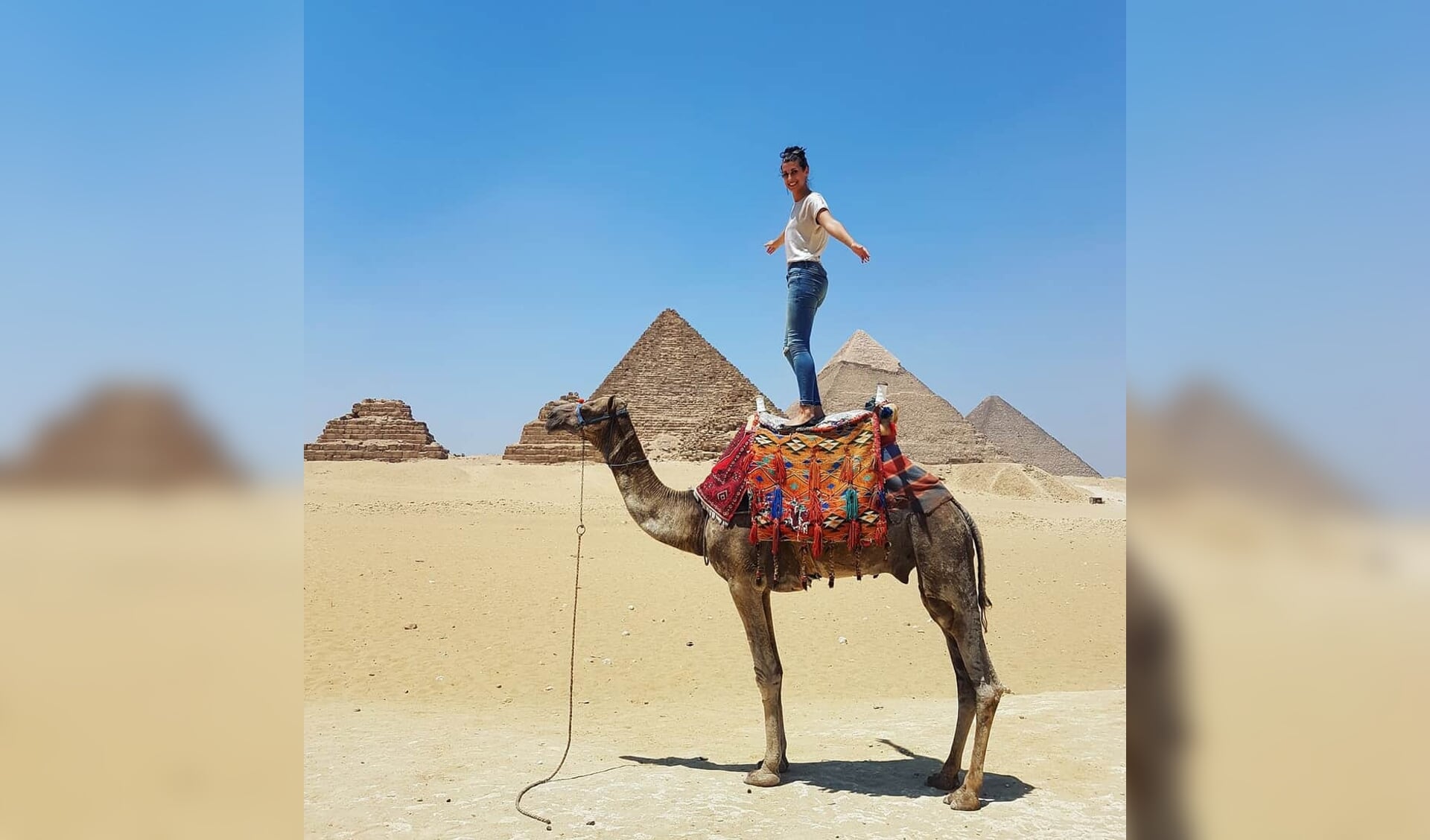 Lilian Plantinga op een kameel voor de piramides van Gizah.