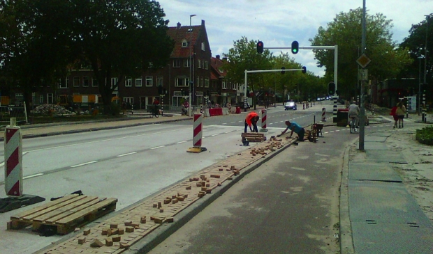 De laatste hand aan de bestrating wordt gelegd.