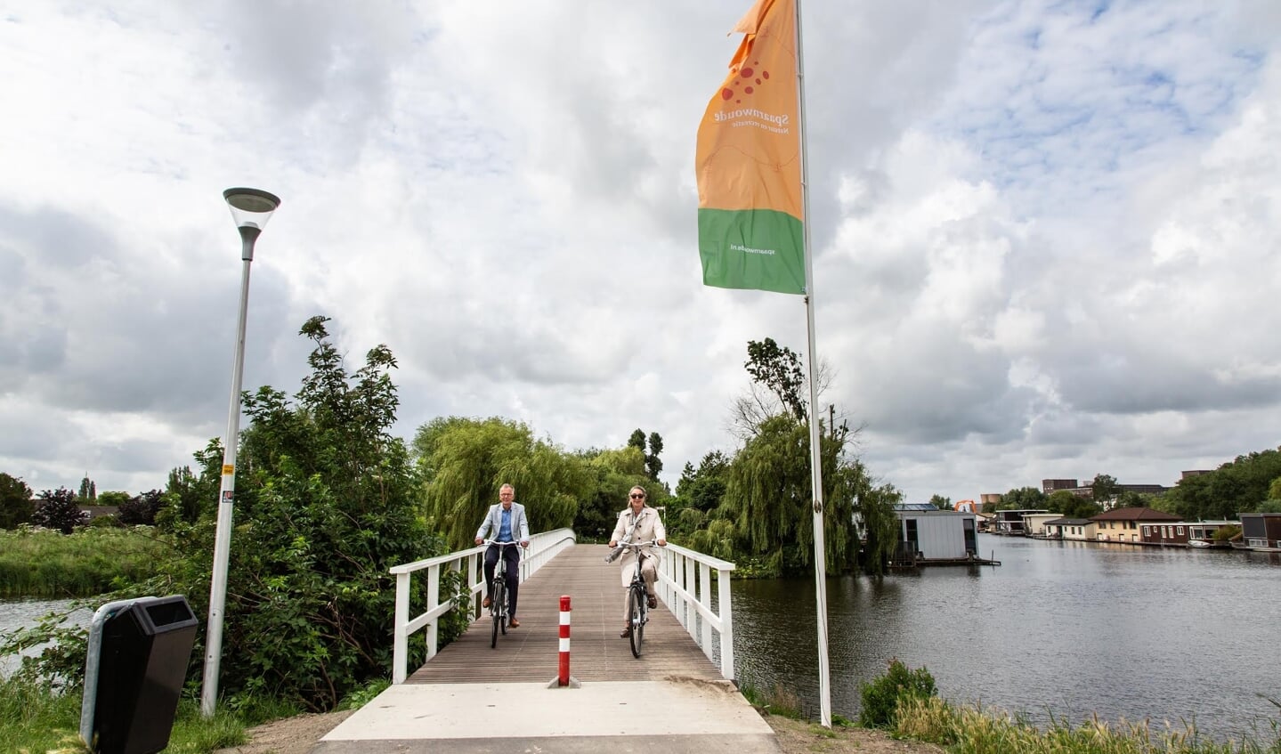 Wethouder Mariëtte Sedee en Marco Kastelein van het hoogheemraadschap nemen de vernieuwde brug in gebruik.