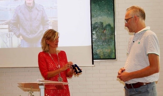 Vanwege gezondheidsredenen werd het lintje van de heer Bakker in ontvangst genomen door zijn zoon.