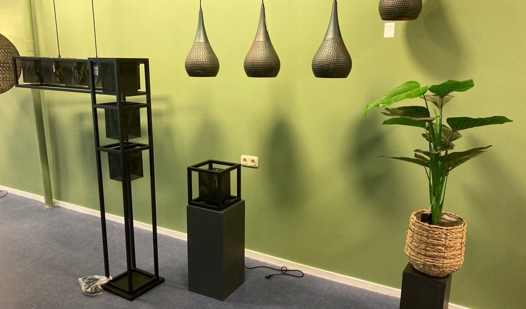 De eerste lampen van de nieuwe collectie tegen een groene wand in de nieuwe winkel. 