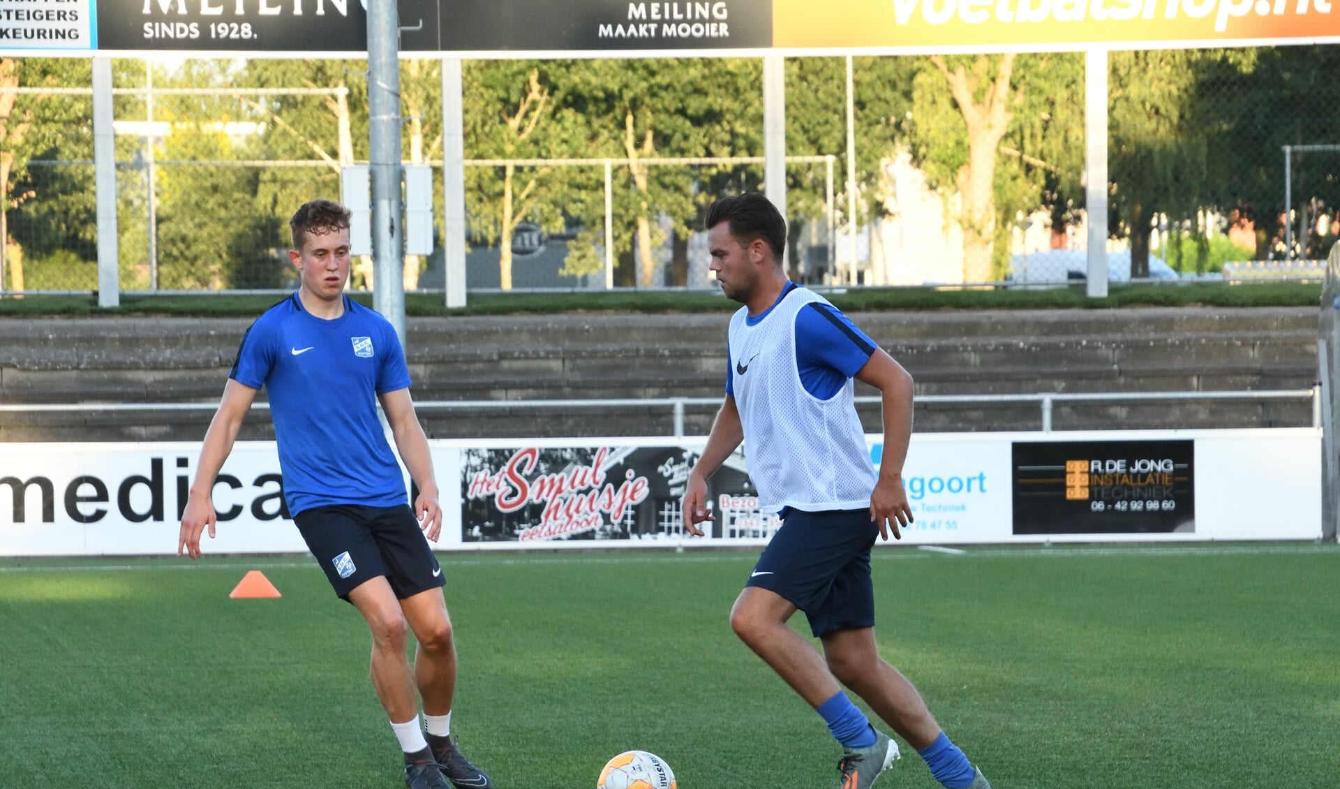 Mauro Franken aan de bal tijdens de training van SDC Putten; links Bart Posthouwer. 