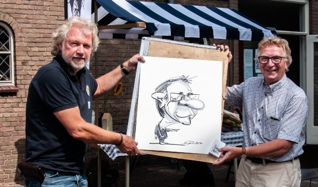 Geert van Rumund en het portret dat hij liet maken op de kunstmarkt door Ronald Kronenburg. (foto: Catalijn Adelmund)