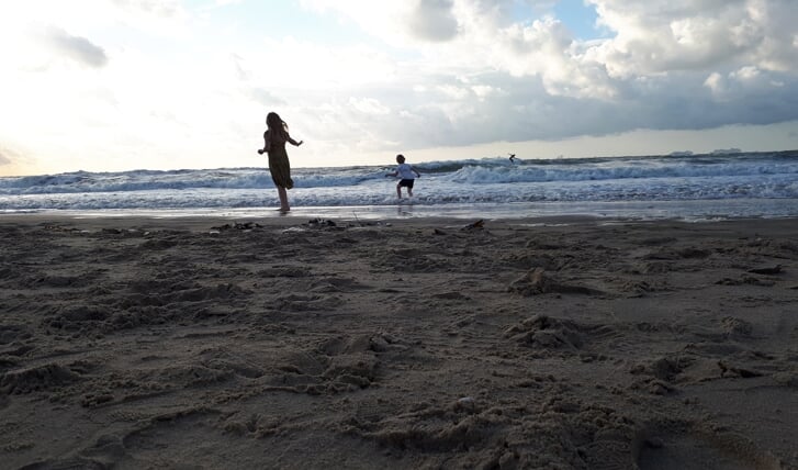 Timo en Sofie aan de Scheveningse kust op zondag 23 augustus. Timo imiteert de surfer op de achtergrond, terwijl zijn zus Sofie staat te genieten van de wind en ondertussen een oogje in het zeil houdt.