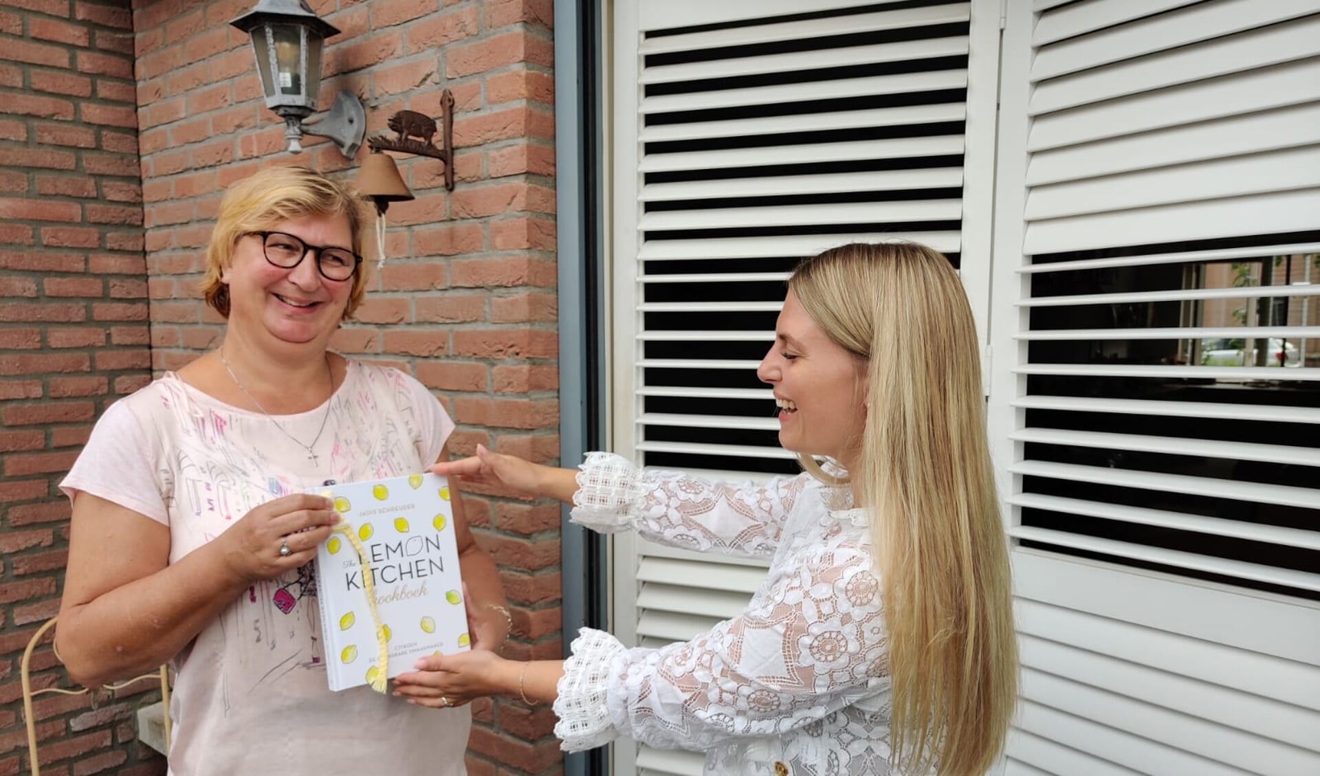 Sandra Rietveld ontvangt haar gewonnen exemplaar van The Lemon Kitchen persoonlijk uit handen van schrijfster Jadis Schreuder