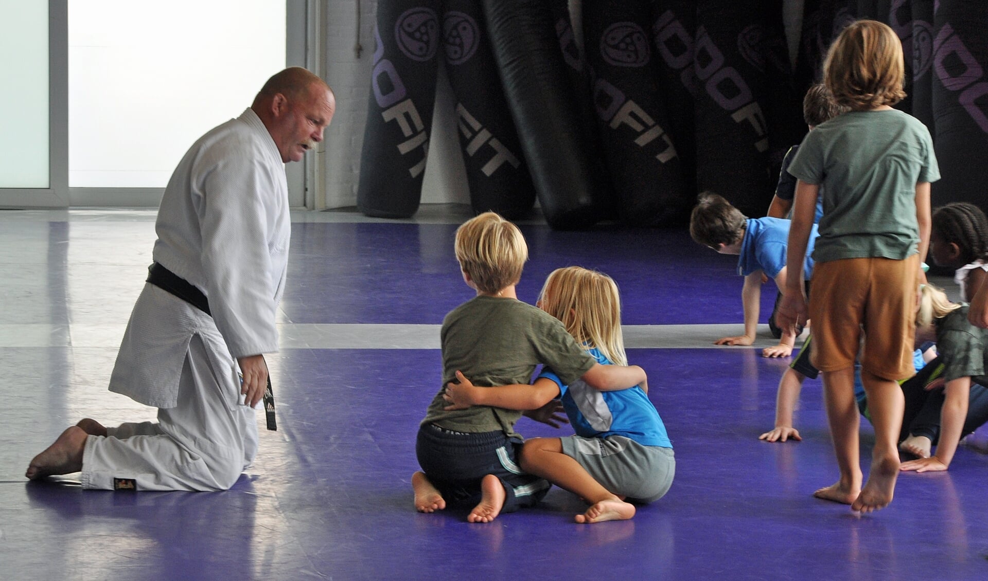 Willo Ankone leert de kinderen de beginselen van het judo.