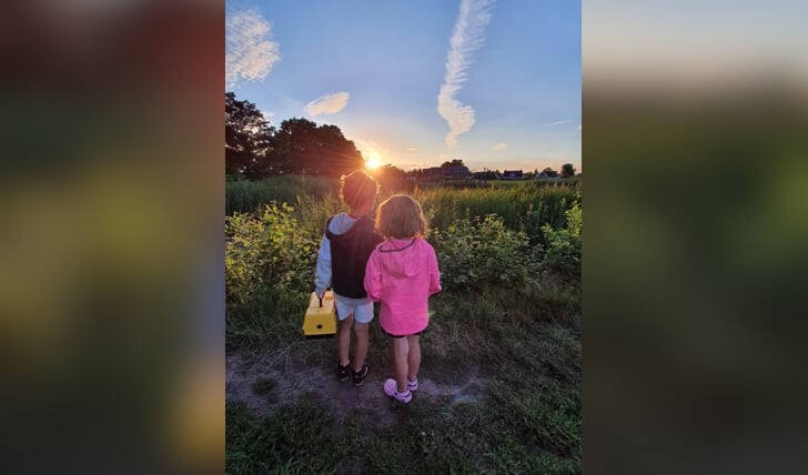 Jesse en Inge Kelderman kijken samen naar de zonsondergang na een mooie avond vissen in de vijver in wekerom.  