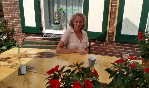 <p>Yvon Hoogendijk in haar theetuin voor de woning</p>