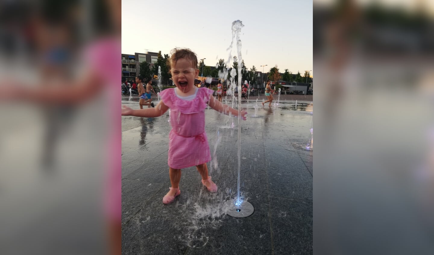 Jennifer Wieland, twee jaar oud, heeft waterpret op het marktplein in Ede.