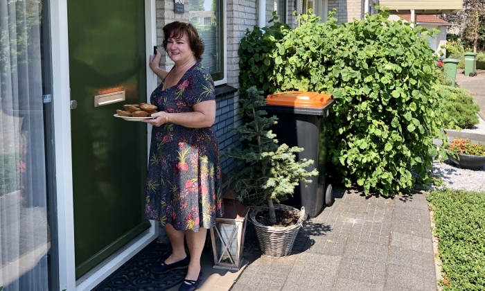 Een vrijwilliger brengt taartjes rond.