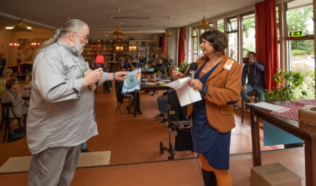 <p>Marjo Stam reikt het eerste Lokaal-O kookboek uit aan Koos Rooyen, gast van het eerste uur van Lokaal-O. </p>
