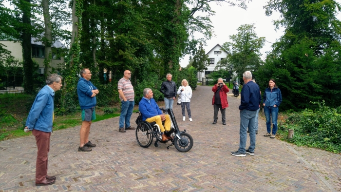 Deelnemers aan de wandeling luisteren naar Martin Wigtman