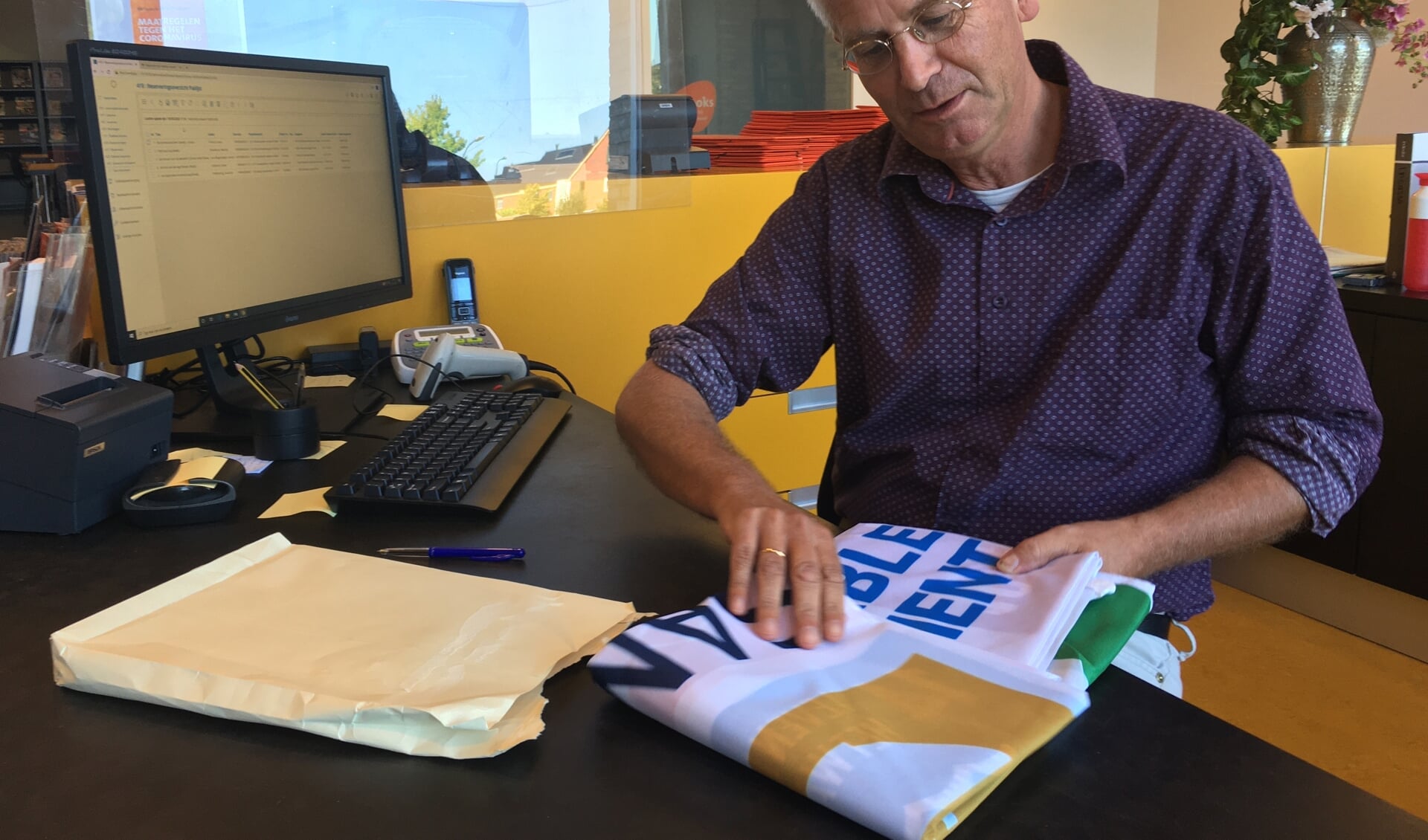 Alfred Haaksma opent de envelop met de vlag.