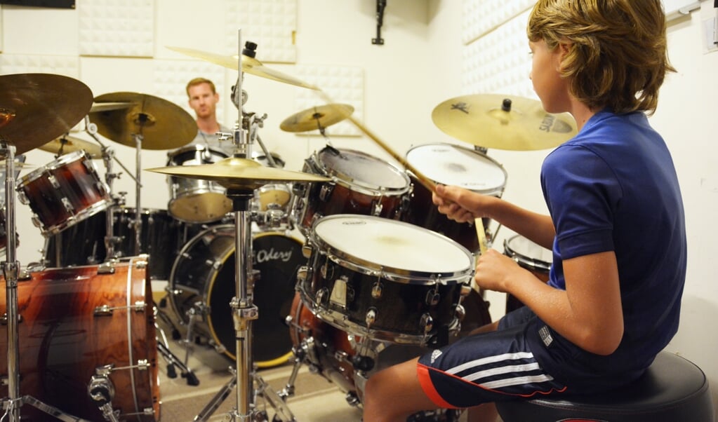 Een leerling krijgt een proefles drums