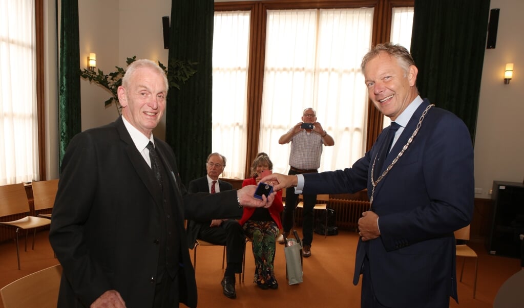 Jan Naber ontvangt de onderscheiding uit handen van burgemeester Mark Röell.