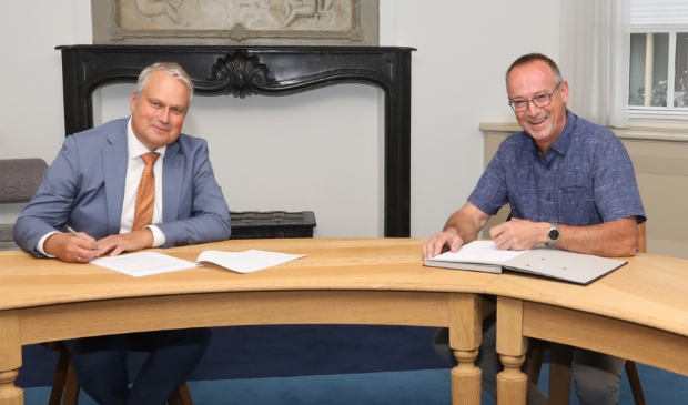 <p>Wethouder Wim Oosterwijk en Henny Smink (directeur Smink Vastgoed) tekenen van de overeenkomst bouwplan de Hofstee in Doornsteeg in Nijkerk.</p>