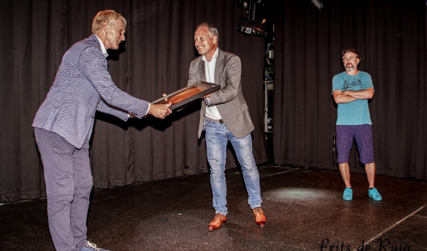 Wethouder Kiel (midden) reikt één van de gouden platen uit.